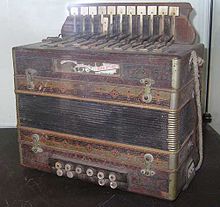 A musical instrument about the size of a harpsichord, with keys, buttons and bellows.