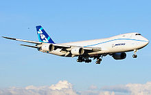 Quarter view of quadjet on approach over clouds.