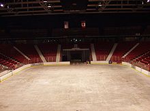 An empty arena with the sheet of ice and the score board