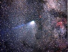 Halley's Comet, tail barely visible, against a background of stars. The Milky Way is seen in the background.