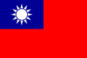 A red flag, with a small blue rectangle in the top left hand corner on which sits a white sun composed of a circle surrounded by 12 rays.