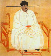 Painted image of a portly man sitting in a red throne-chair with dragon-head decorations, wearing white silk robes, black shoes, and a black hat, and sporting a black mustache and goatee.